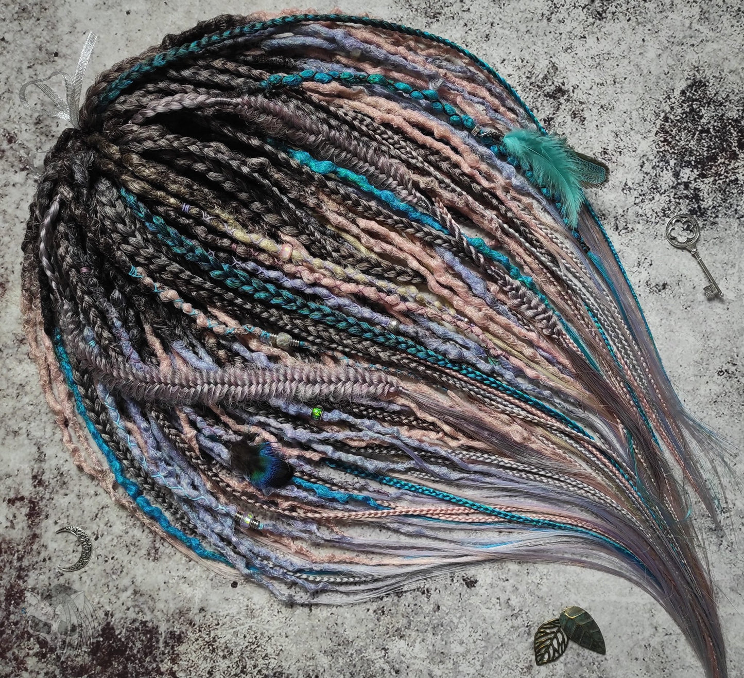 Pastel synthetic dreads with turquoise and brown-to-pink ombre extensions, including purple accents.