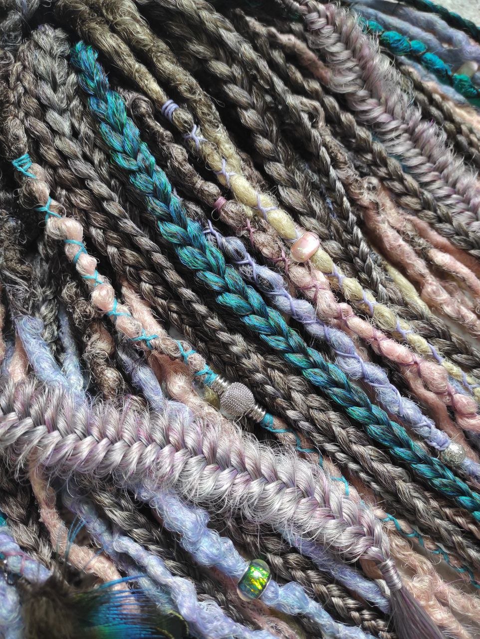 Pastel synthetic dreads with turquoise and brown-to-pink ombre extensions, including purple accents.