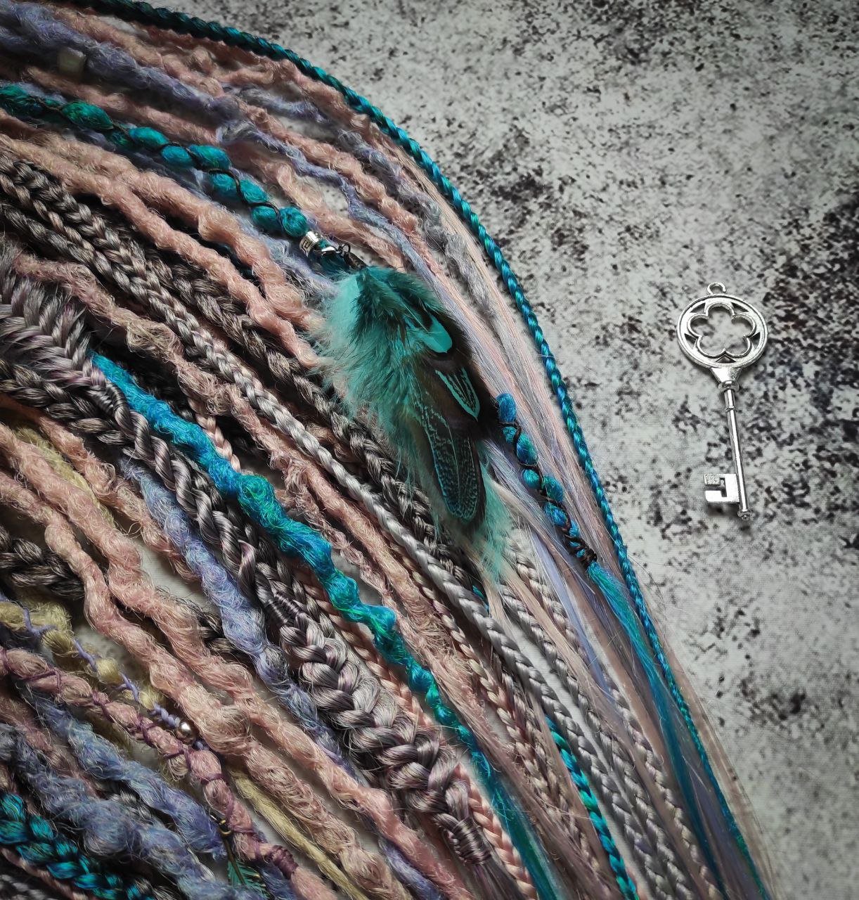 Pastel synthetic dreads with turquoise and brown-to-pink ombre extensions, including purple accents.