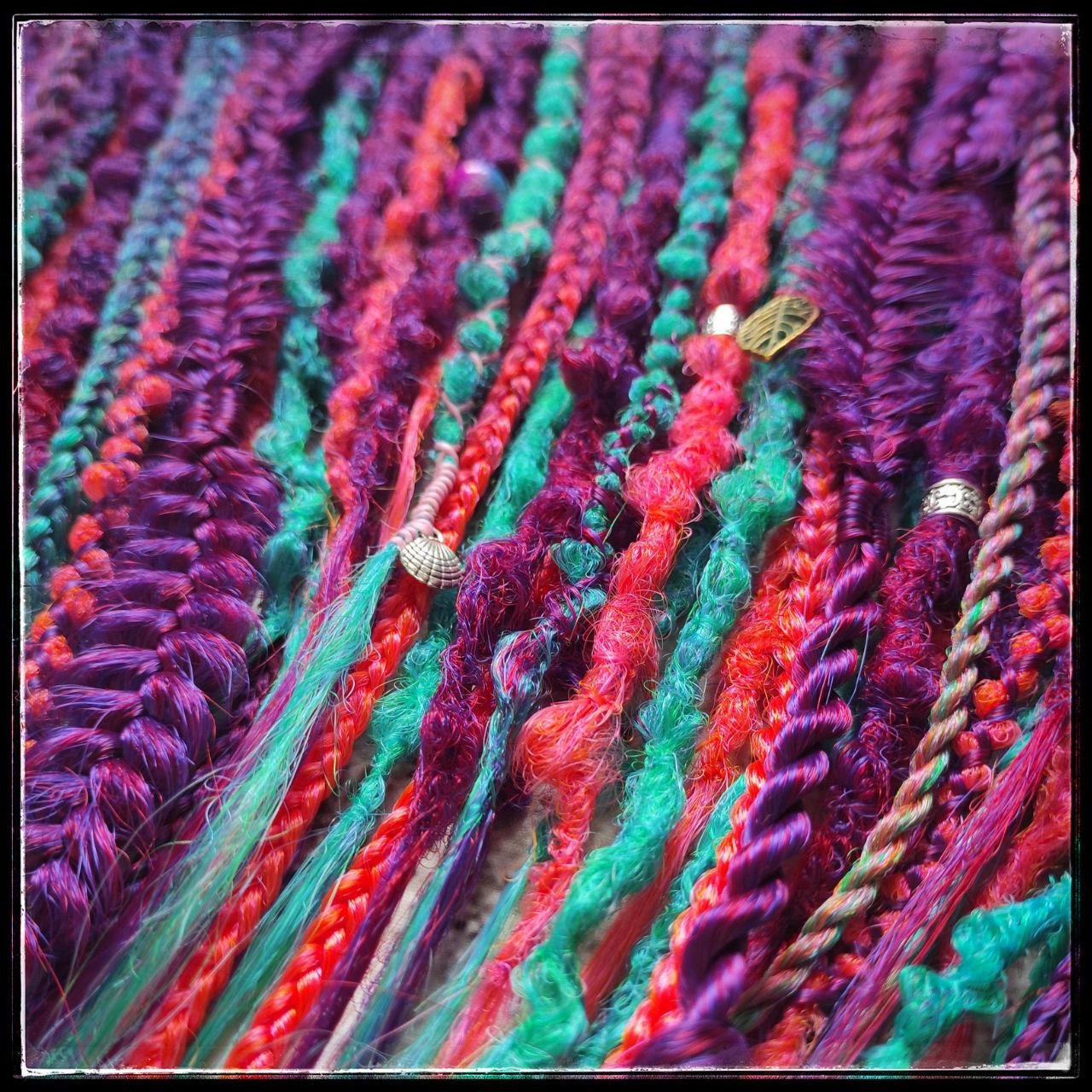 Synthetic dreads with braids featuring a striking ombre effect transitioning from purple to green and orange
