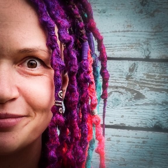 Synthetic dreads with braids featuring a striking ombre effect transitioning from purple to green and orange