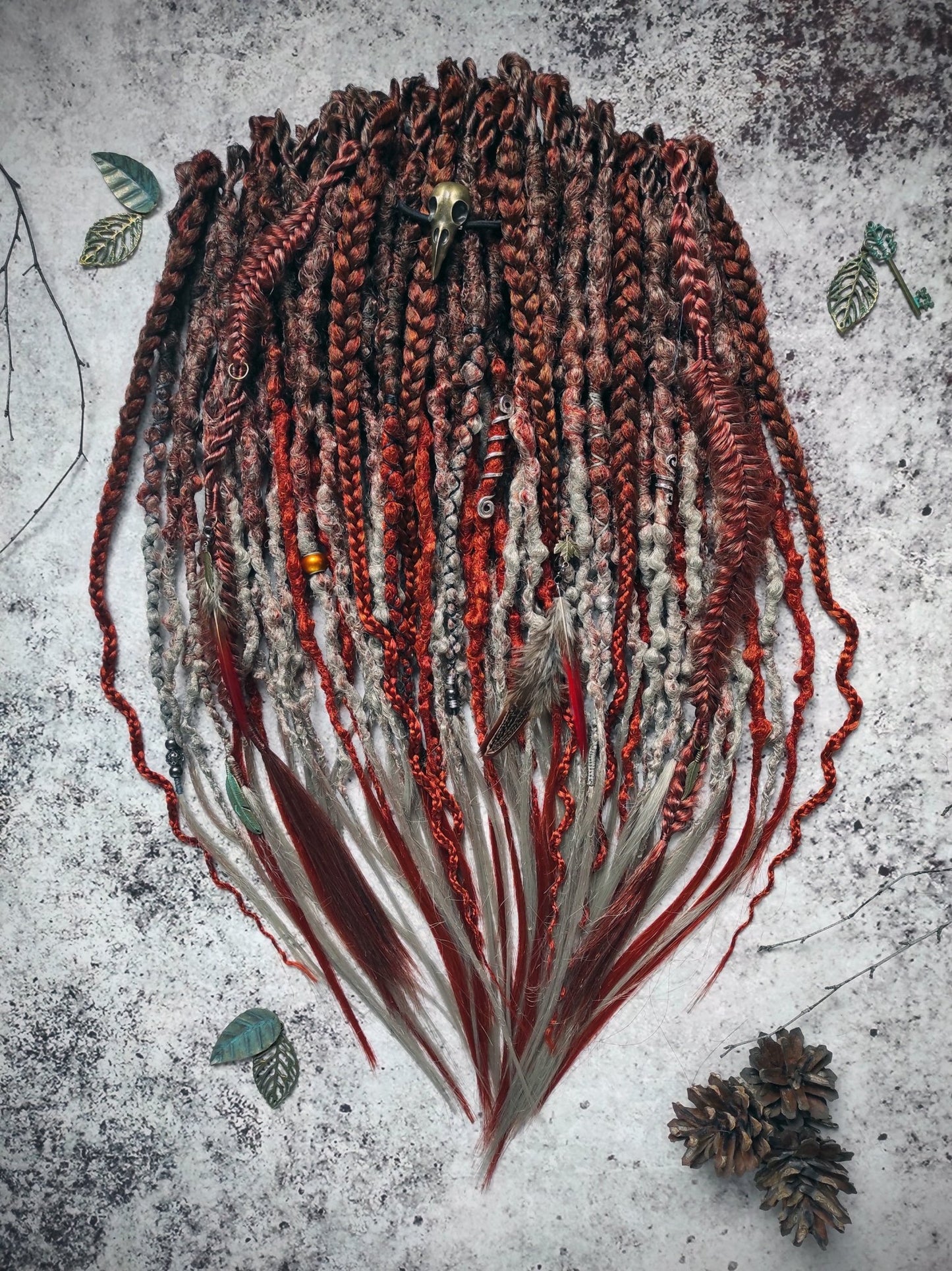 Synthetic dreads with an ombre transition from red auburn to gray, complemented by braids.