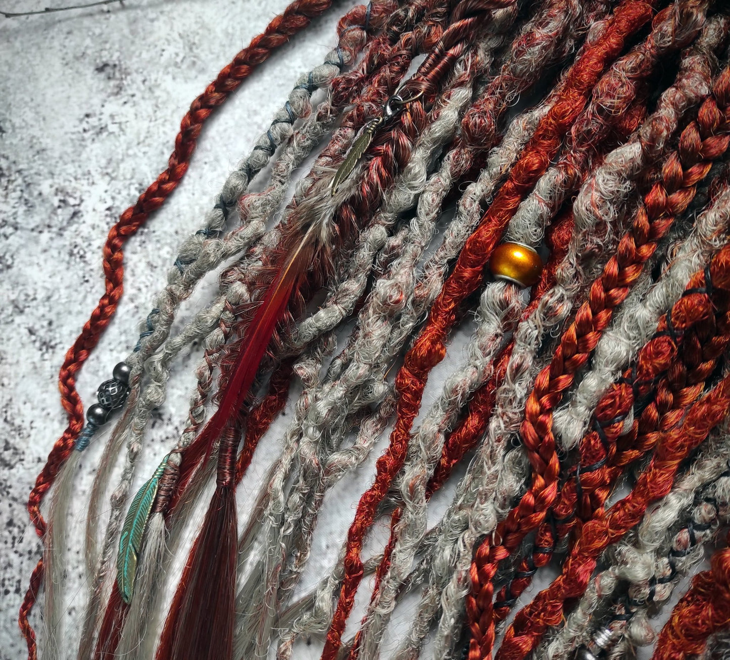Synthetic dreads featuring a red auburn ombre transitioning to gray, complemented by braids