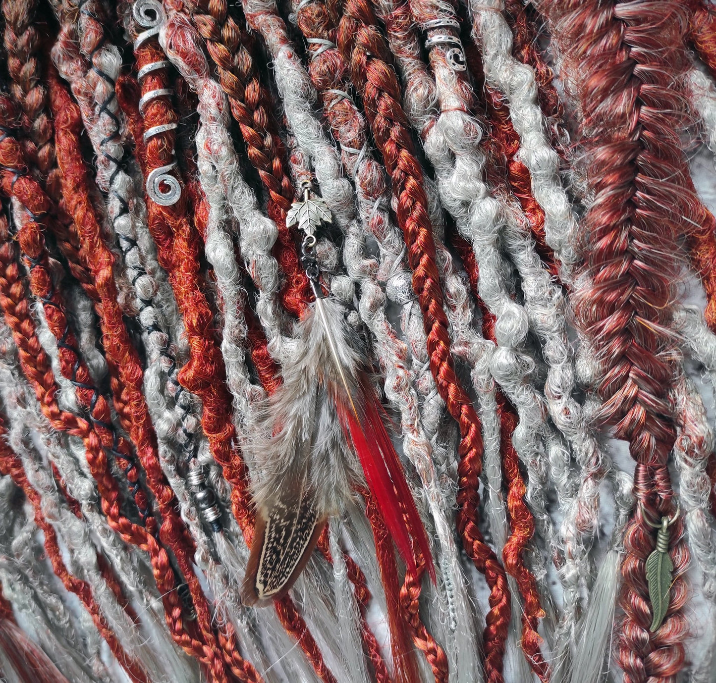 Synthetic dreads with an ombre transition from red auburn to gray, complemented by braids.