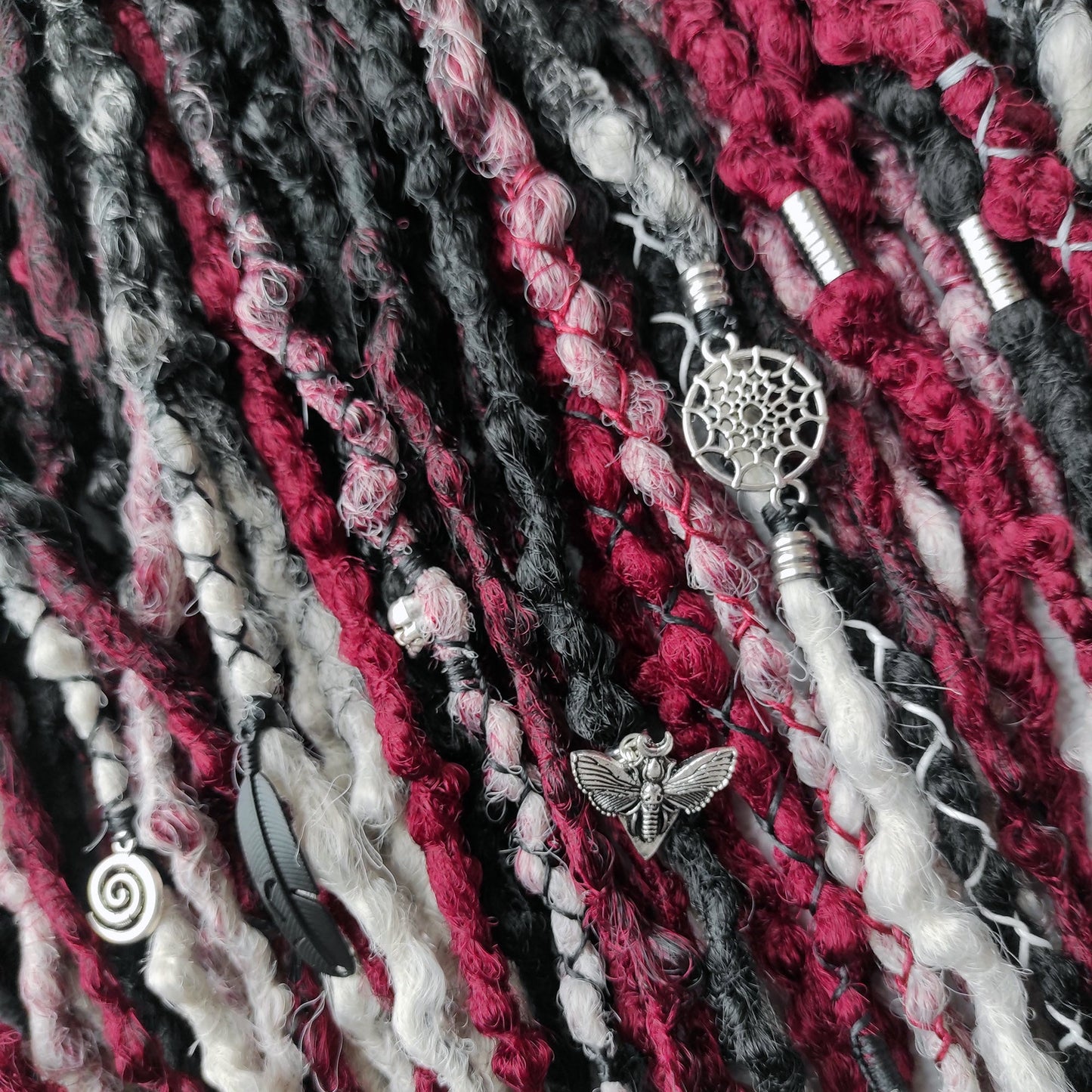 Synthetic dreads transitioning from solid black to red and grey ombre.