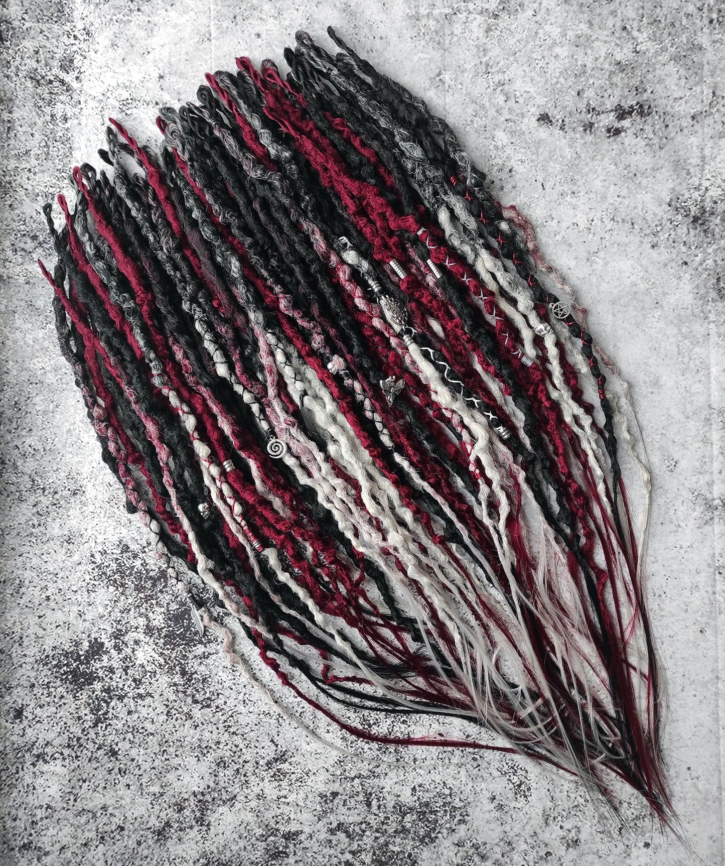 Synthetic dreads transitioning from solid black to red and grey ombre.