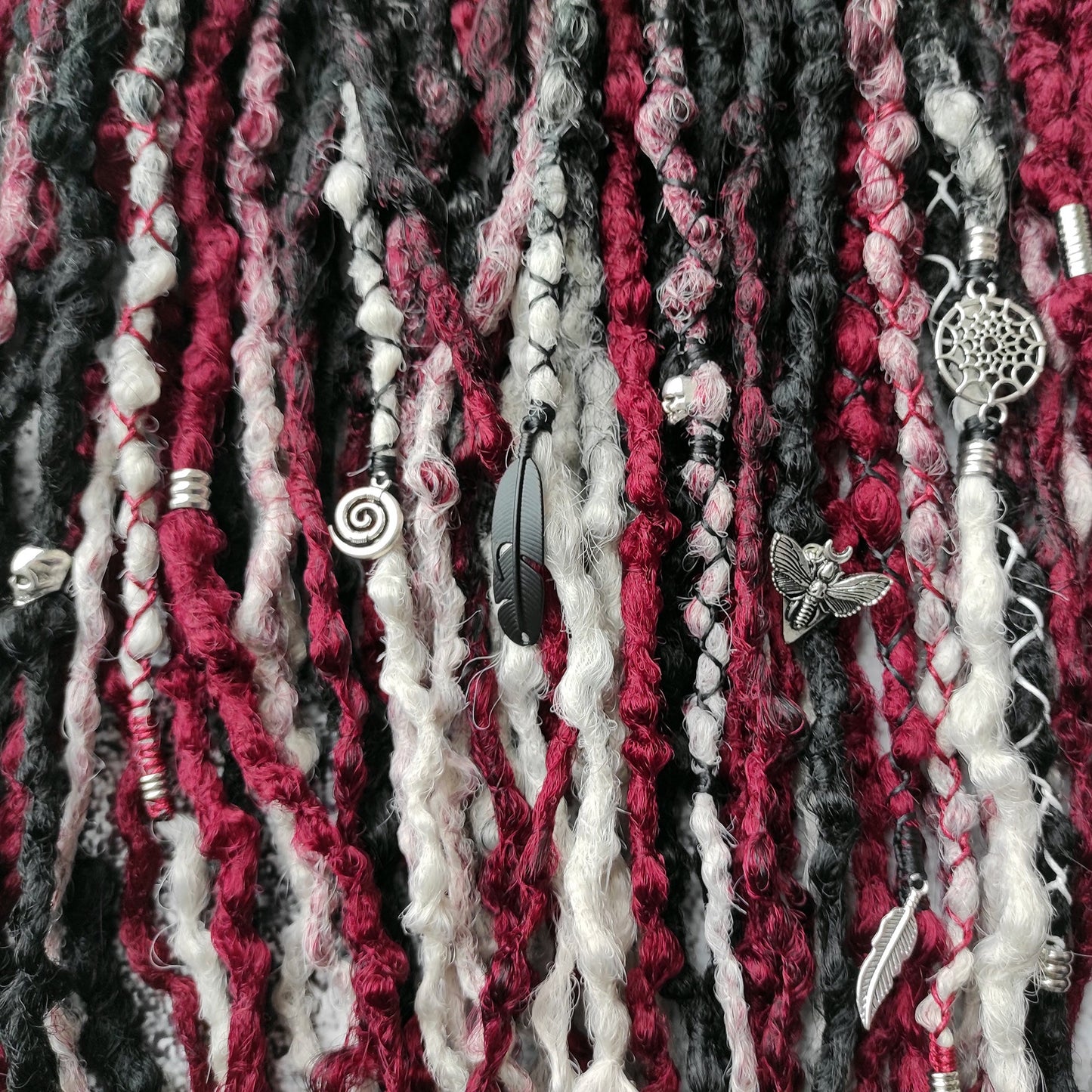 Synthetic dreads transitioning from solid black to red and grey ombre.