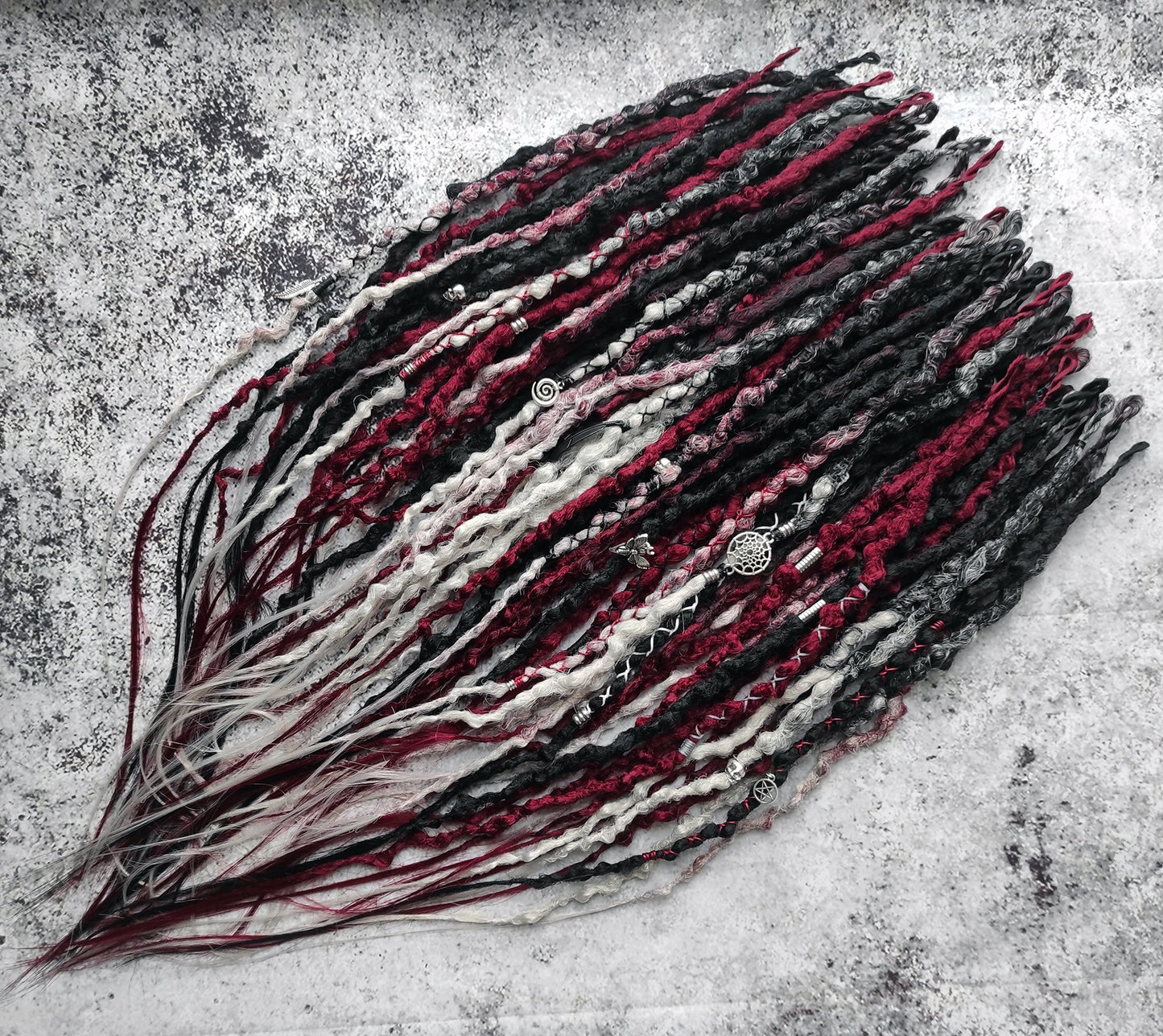 Synthetic dreads transitioning from solid black to red and grey ombre.