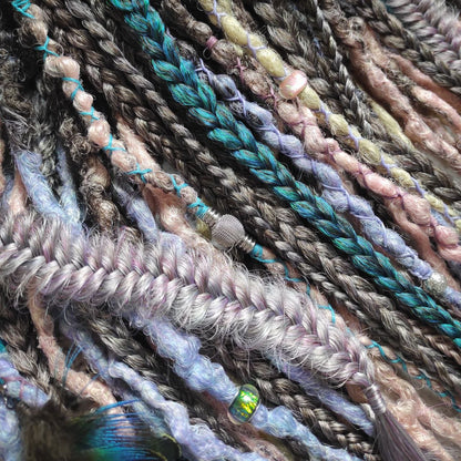 Pastel synthetic dreads with turquoise and brown-to-pink ombre extensions, including purple accents.