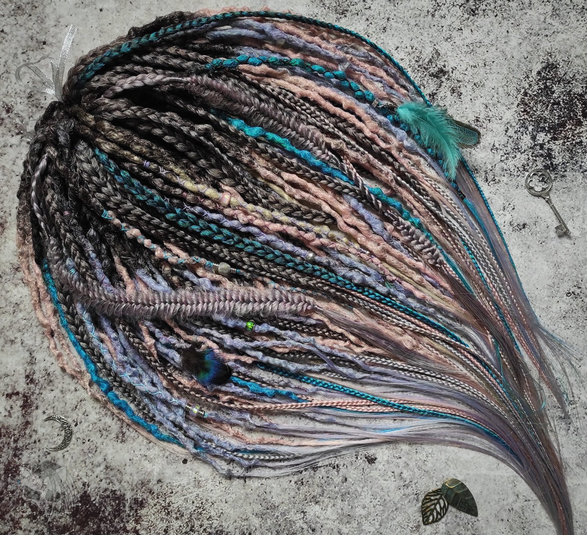 Pastel synthetic dreads with turquoise and brown-to-pink ombre extensions, including purple accents.