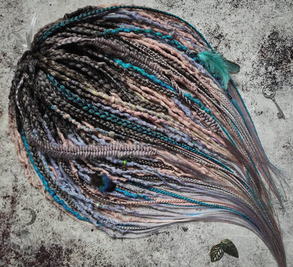 Pastel synthetic dreads with turquoise and brown-to-pink ombre extensions, including purple accents.