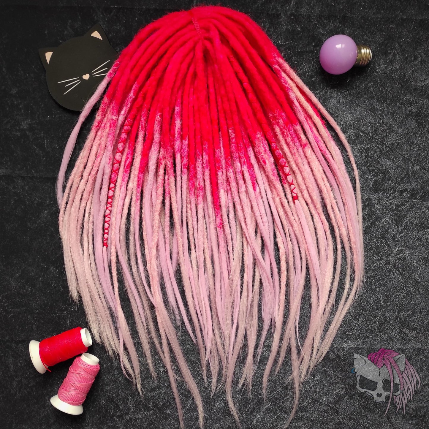 Synthetic double-ended dreads with a pink ombre effect