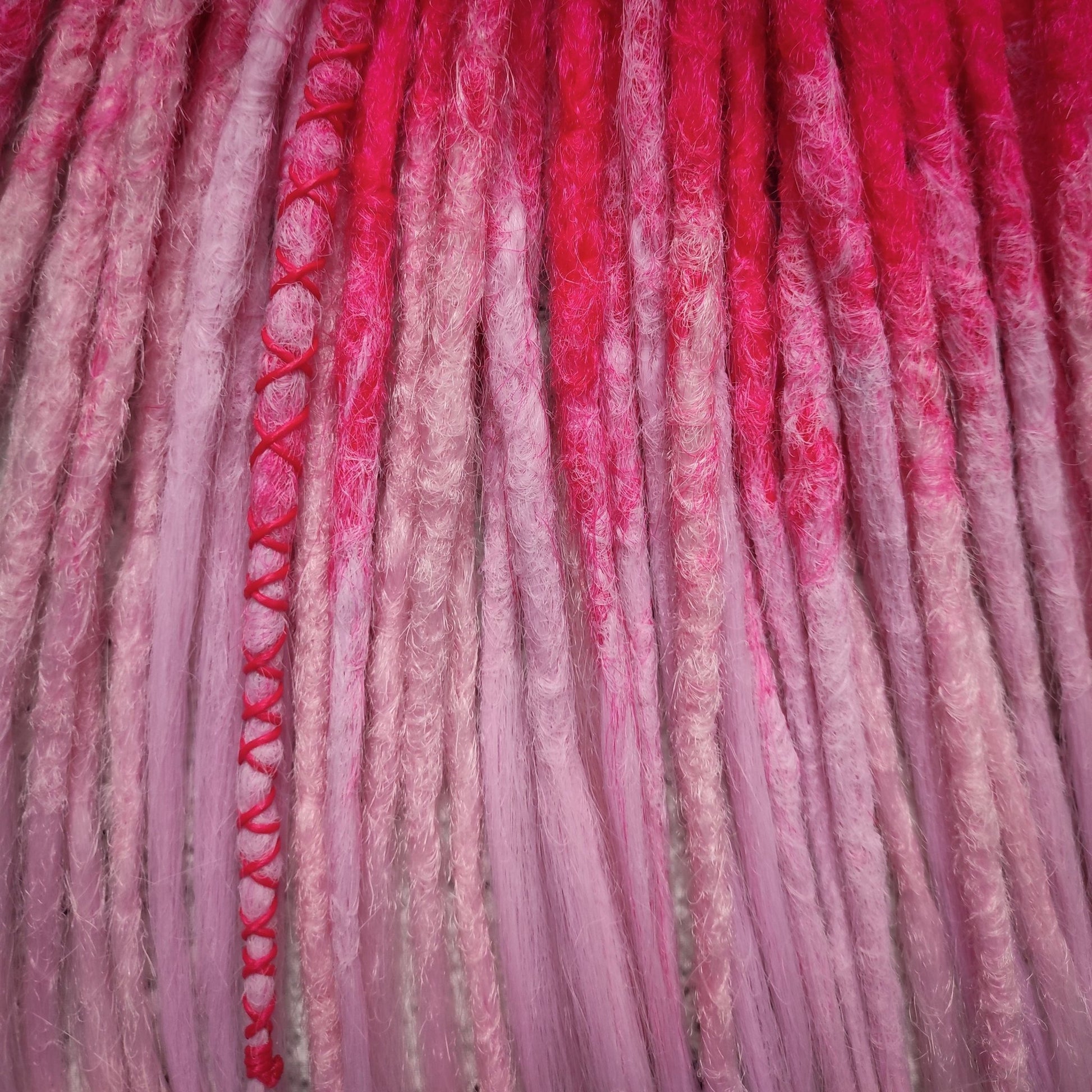 Synthetic double-ended dreads with a pink ombre effect