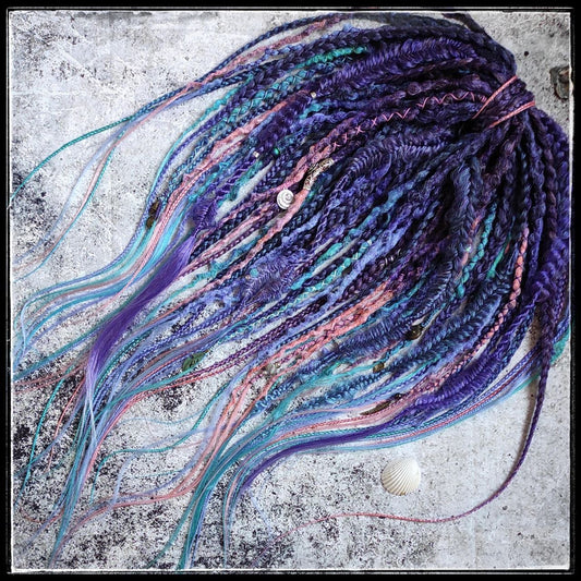 Synthetic dreads in purple, featuring ombre extensions transitioning from brown to pink, turquoise, and blue, along with braids