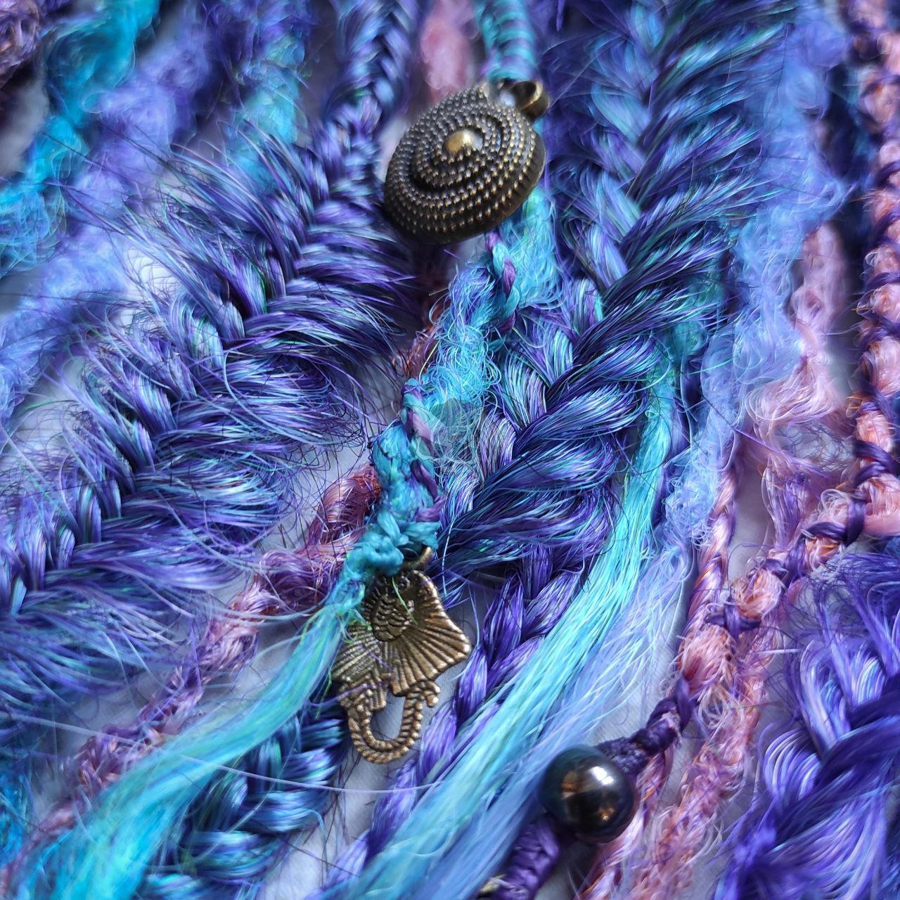 Synthetic dreads in purple, featuring ombre extensions transitioning from brown to pink, turquoise, and blue, along with braids