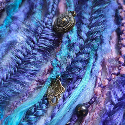 Synthetic dreads in purple, featuring ombre extensions transitioning from brown to pink, turquoise, and blue, along with braids