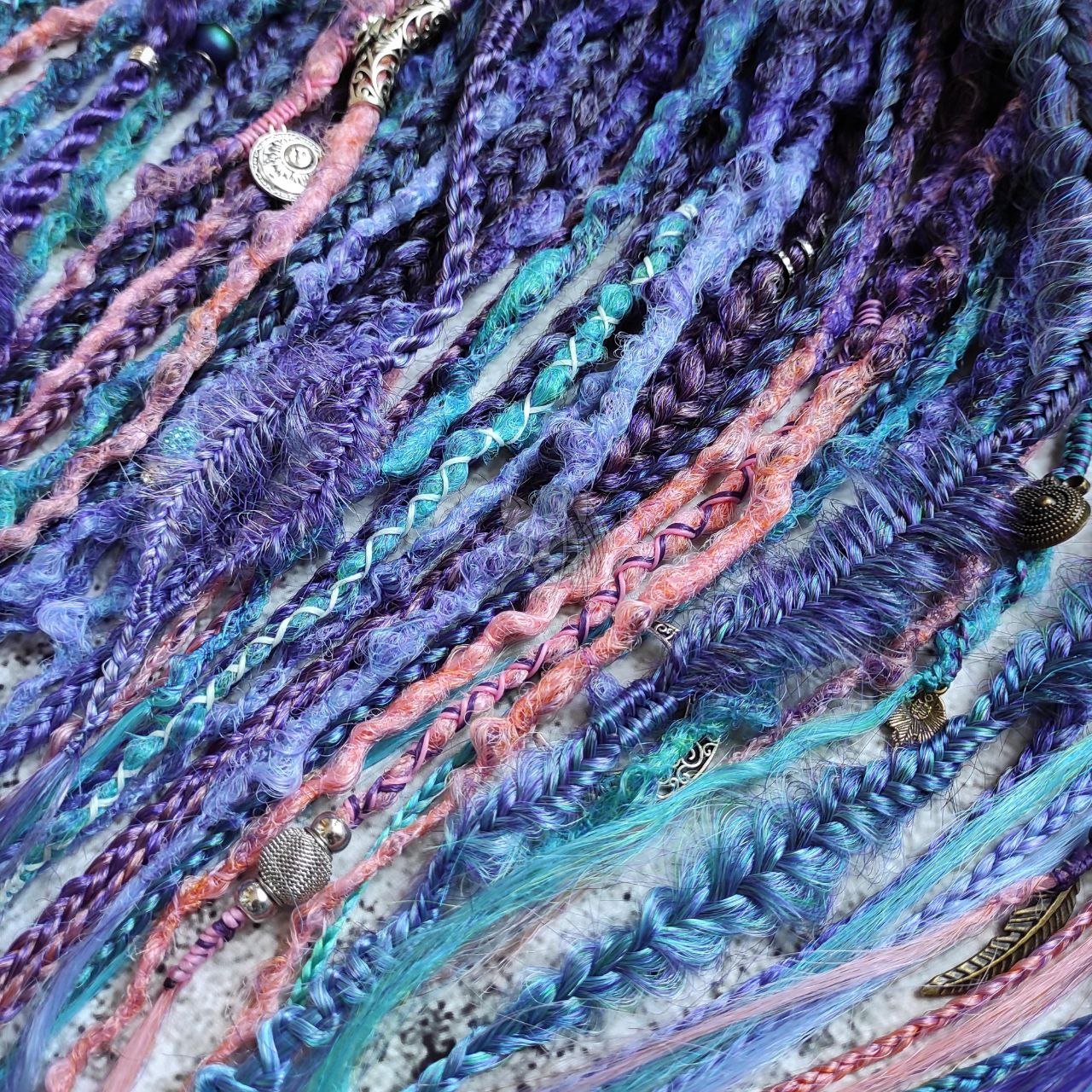 Synthetic dreads in purple, featuring ombre extensions transitioning from brown to pink, turquoise, and blue, along with braids