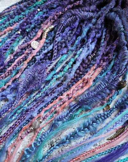 Purple synthetic dreads featuring brown-to-pink, turquoise, and blue ombre extensions, along with braids