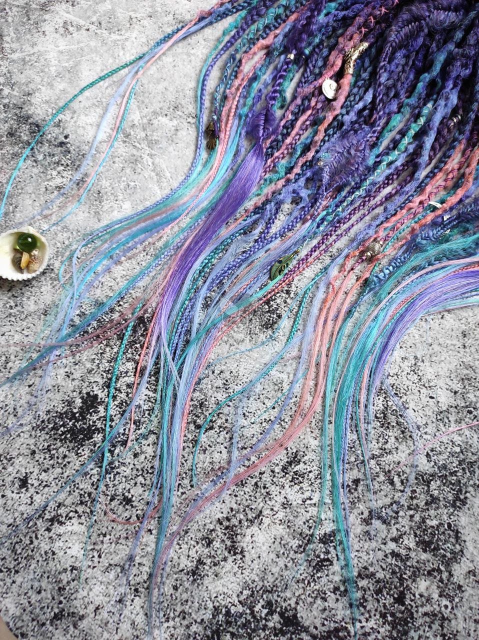 Synthetic dreads in purple, featuring ombre extensions transitioning from brown to pink, turquoise, and blue, along with braids