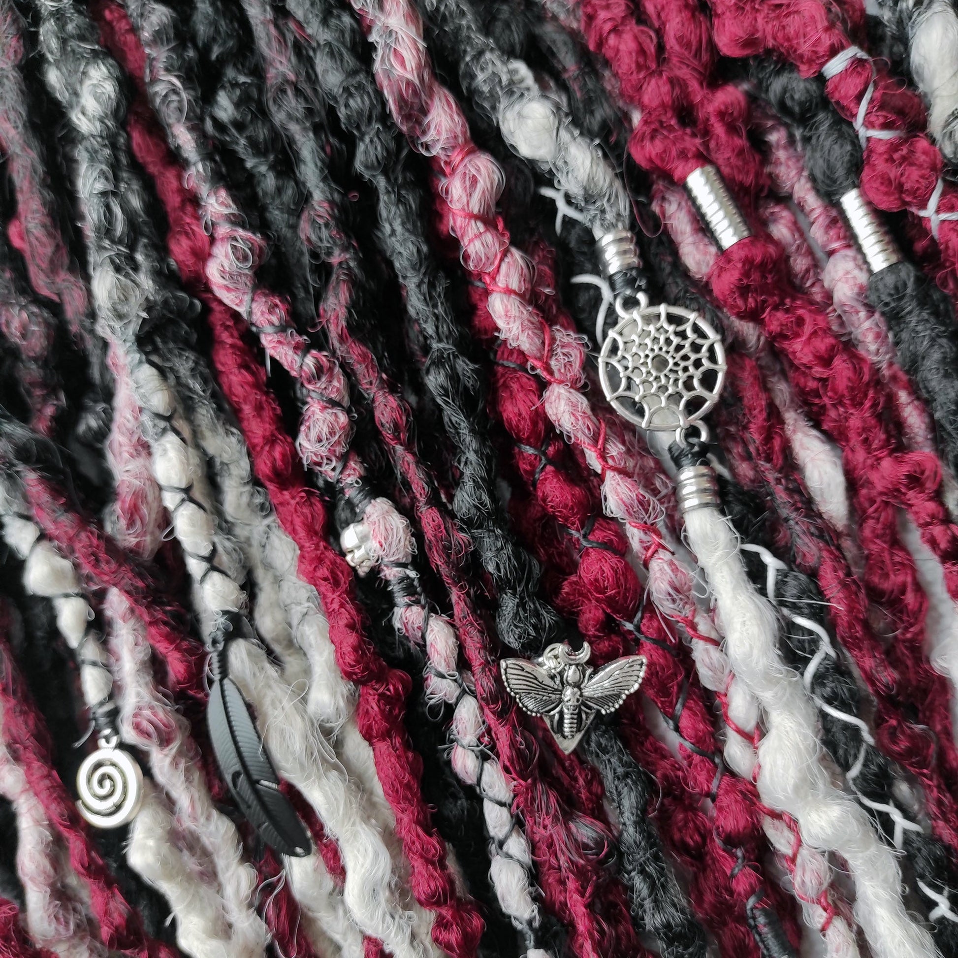 Synthetic dreads transitioning from solid black to red and grey ombre.