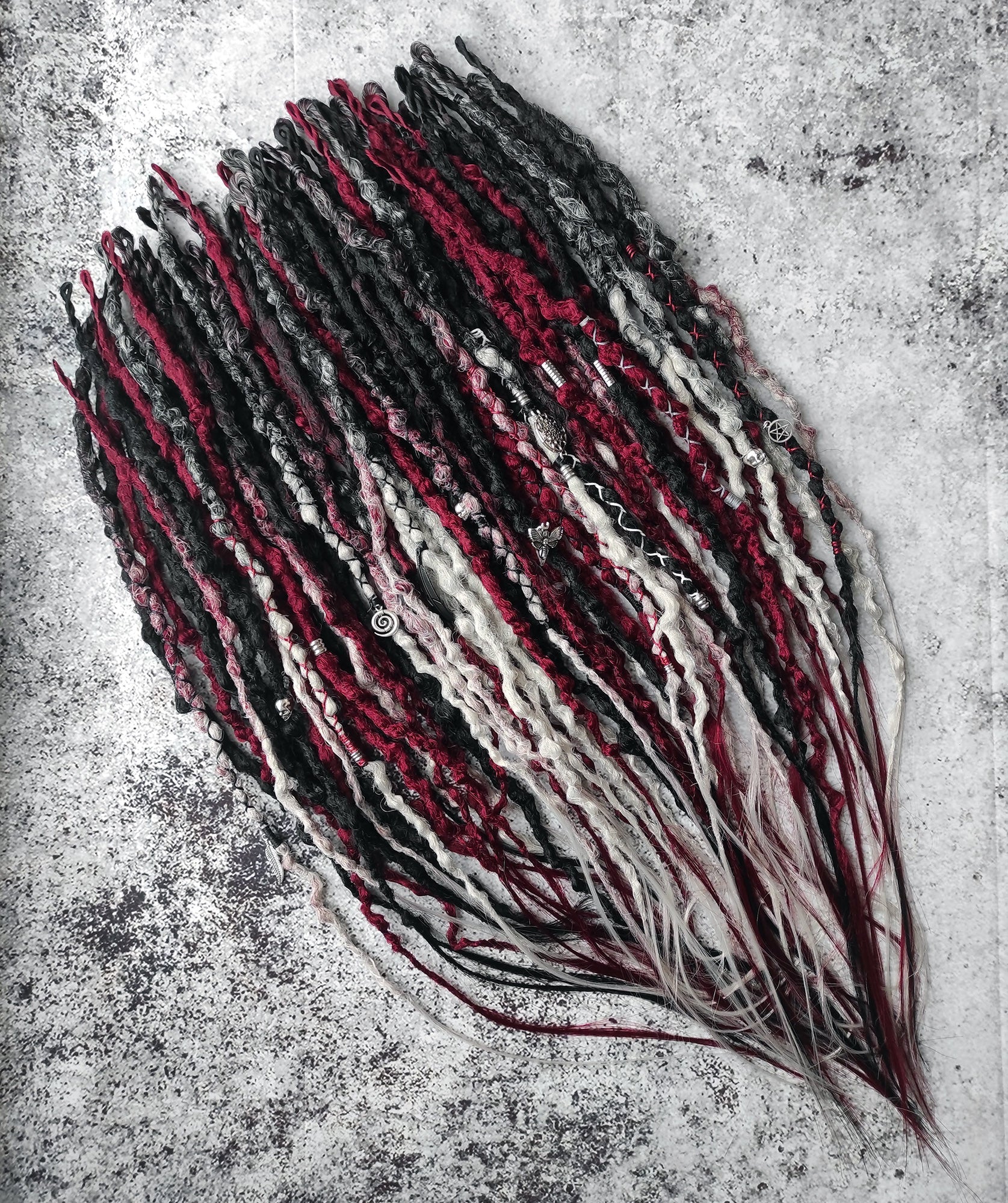 Synthetic dreads transitioning from solid black to red and grey ombre.